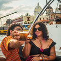 Two people enjoying drinks on a boat to Beach club party on Tierra Bomba