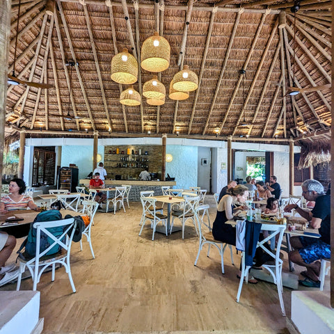People dining in Pedro Majagua restaurant with thatched ceiling and wooden floor.