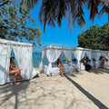 Guests enjoying personal cabanas and Caribbean cuisine at Bora Bora Beach Club